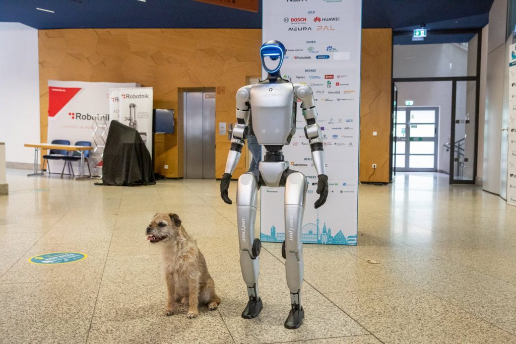 A dog next to a human like robot